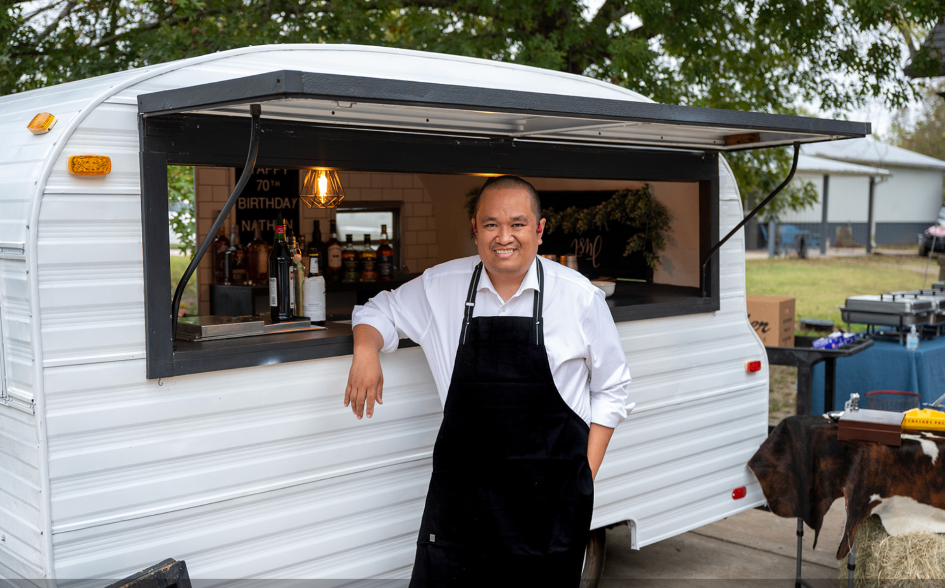 Professional bartender in front of mobile bar trailer